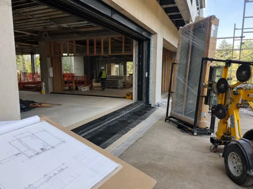 Large glazed door opening coordinated with structure, threshold and installation access