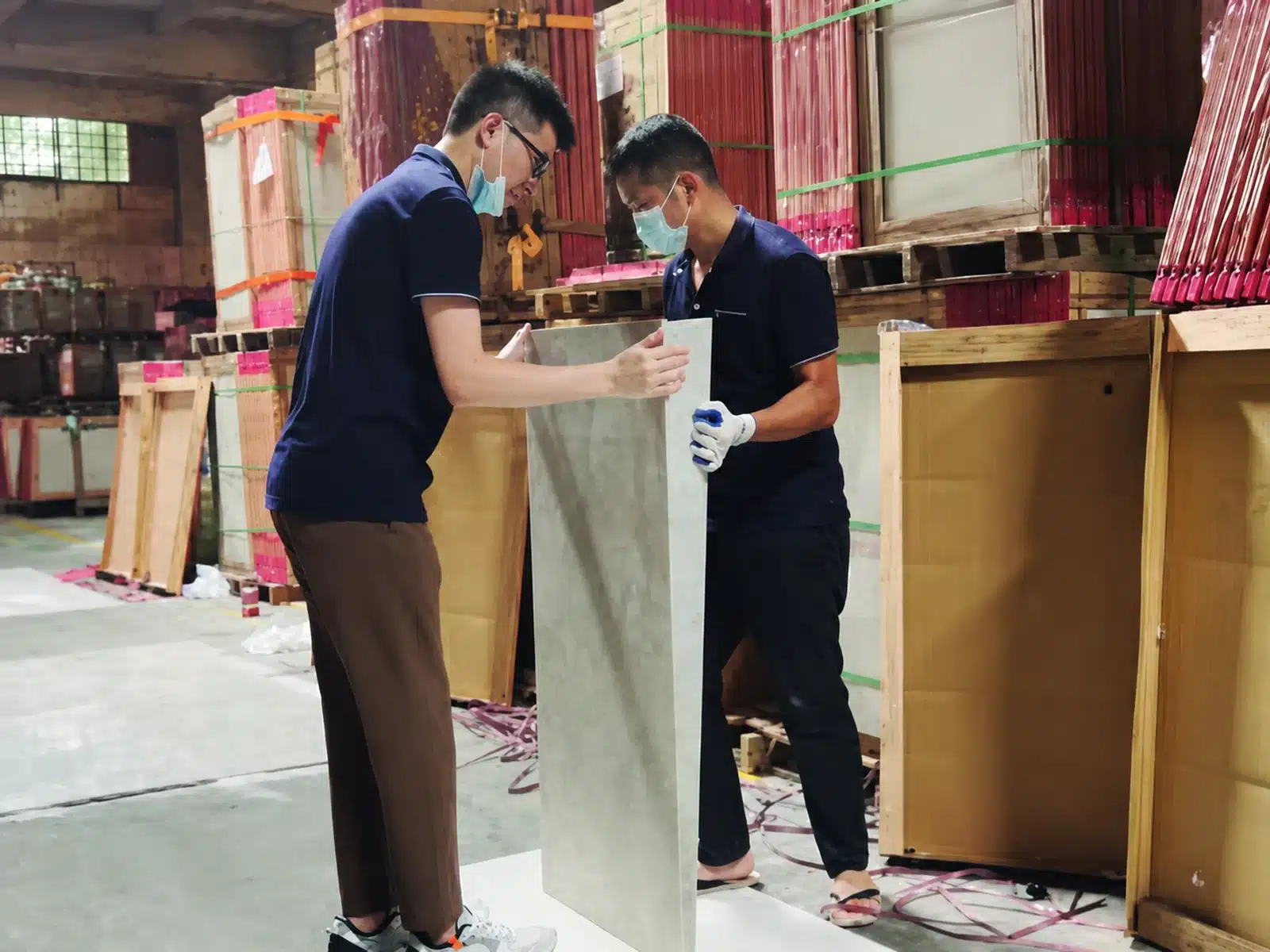 Inspectors checking a finished stone panel before protective packing