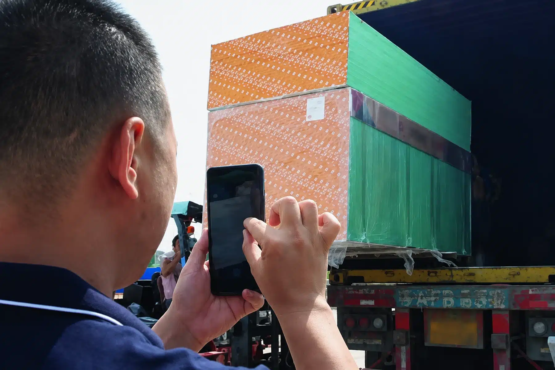 Staff member photographing a loaded container for the shipping handover record