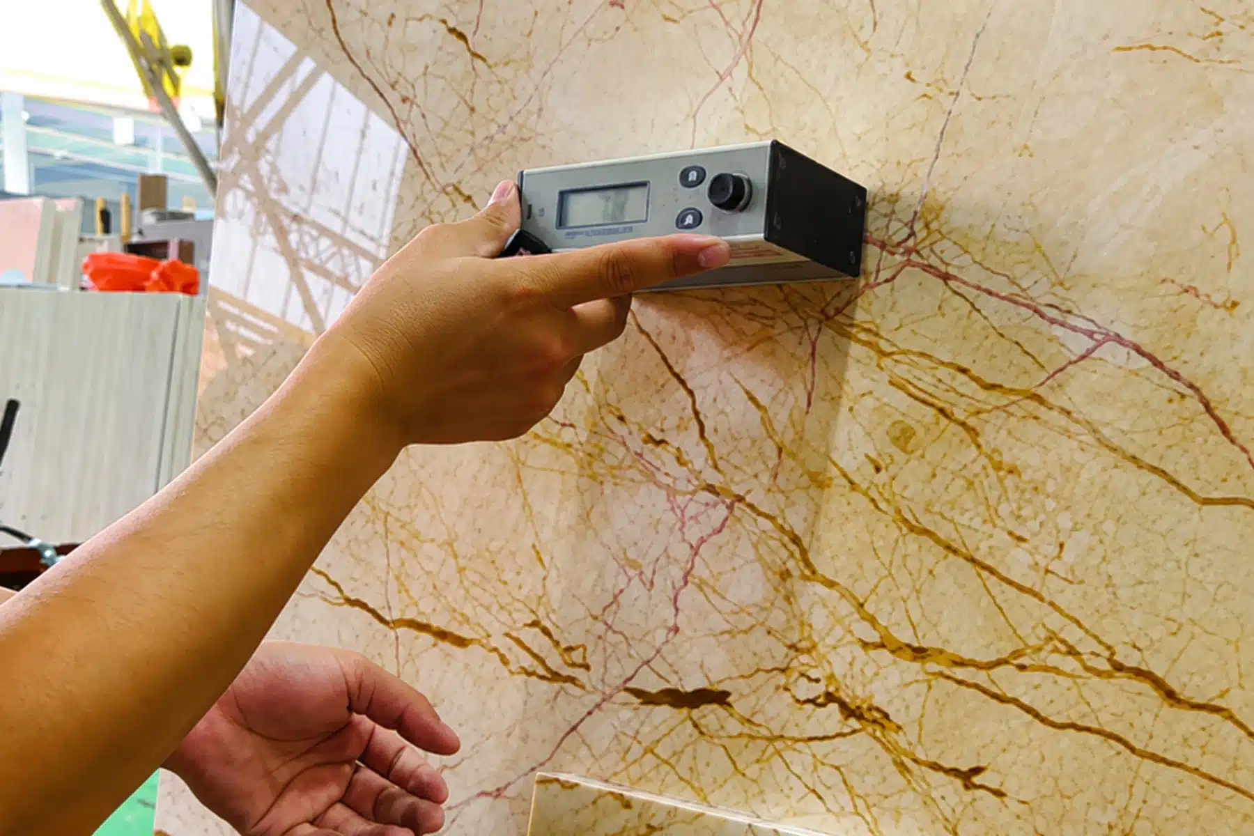 Inspector checking the surface of a stone slab with a handheld device