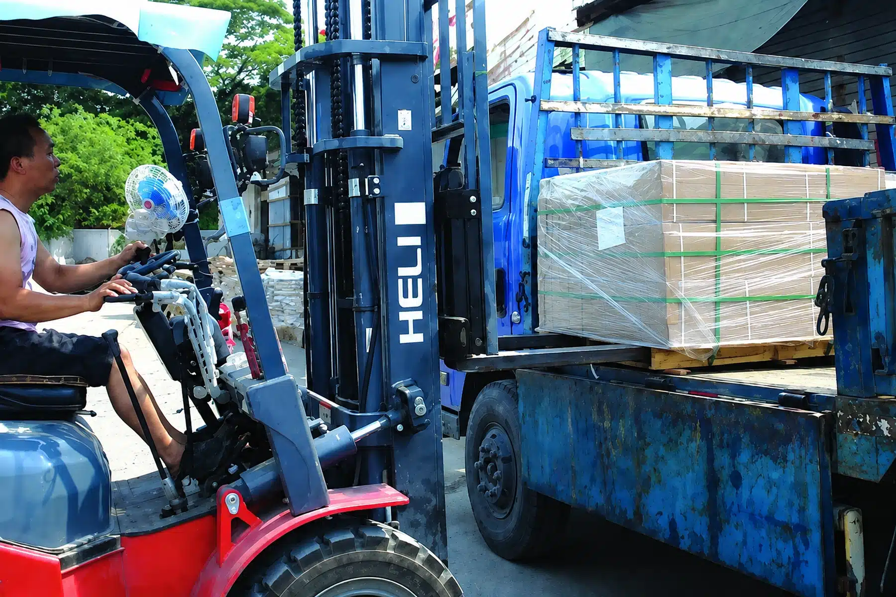 Forklift handling a pallet of building materials at an origin warehouse